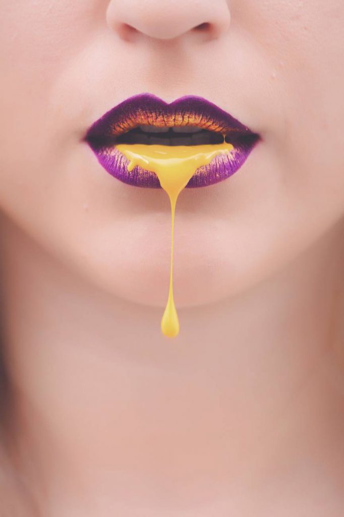 women s purple and yellow lips with yellow liquid